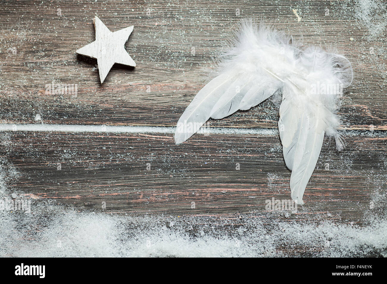 Decorazione di natale, ali d'angelo su legno, stella, neve artificiale,  spazio di copia Foto stock - Alamy