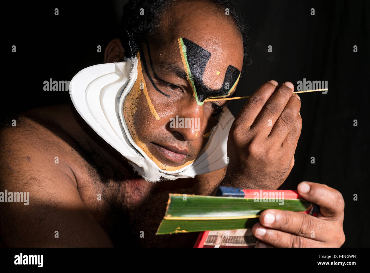 Un artista katakali è applicare il make up del carattere di Shiva per il gioco dhecheyagam Foto Stock