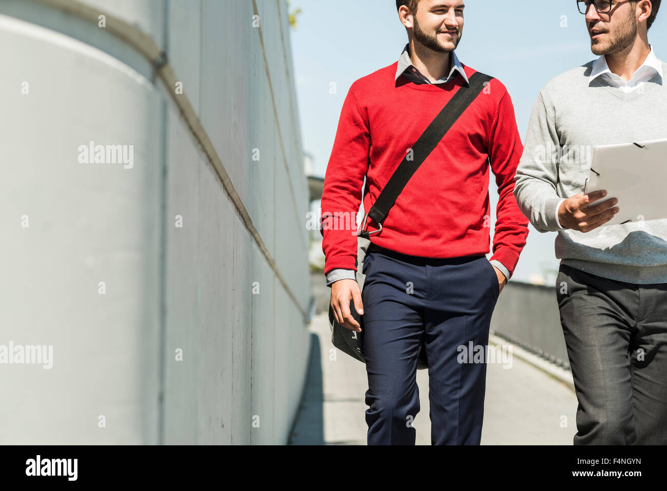 Due giovani imprenditori a piedi in città portando i file Foto Stock