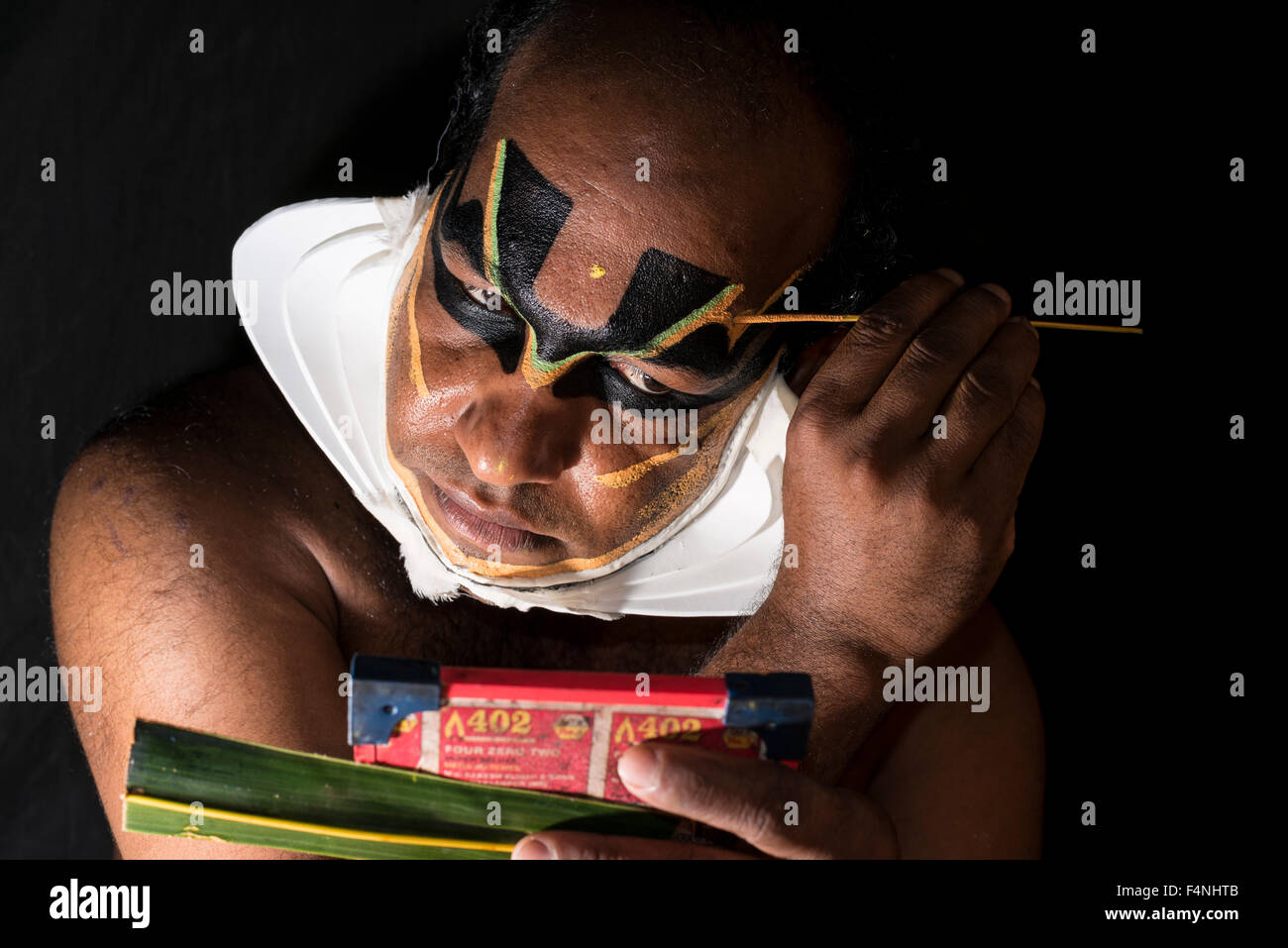 Un artista katakali è applicare il make up del carattere di Shiva per il gioco dhecheyagam Foto Stock