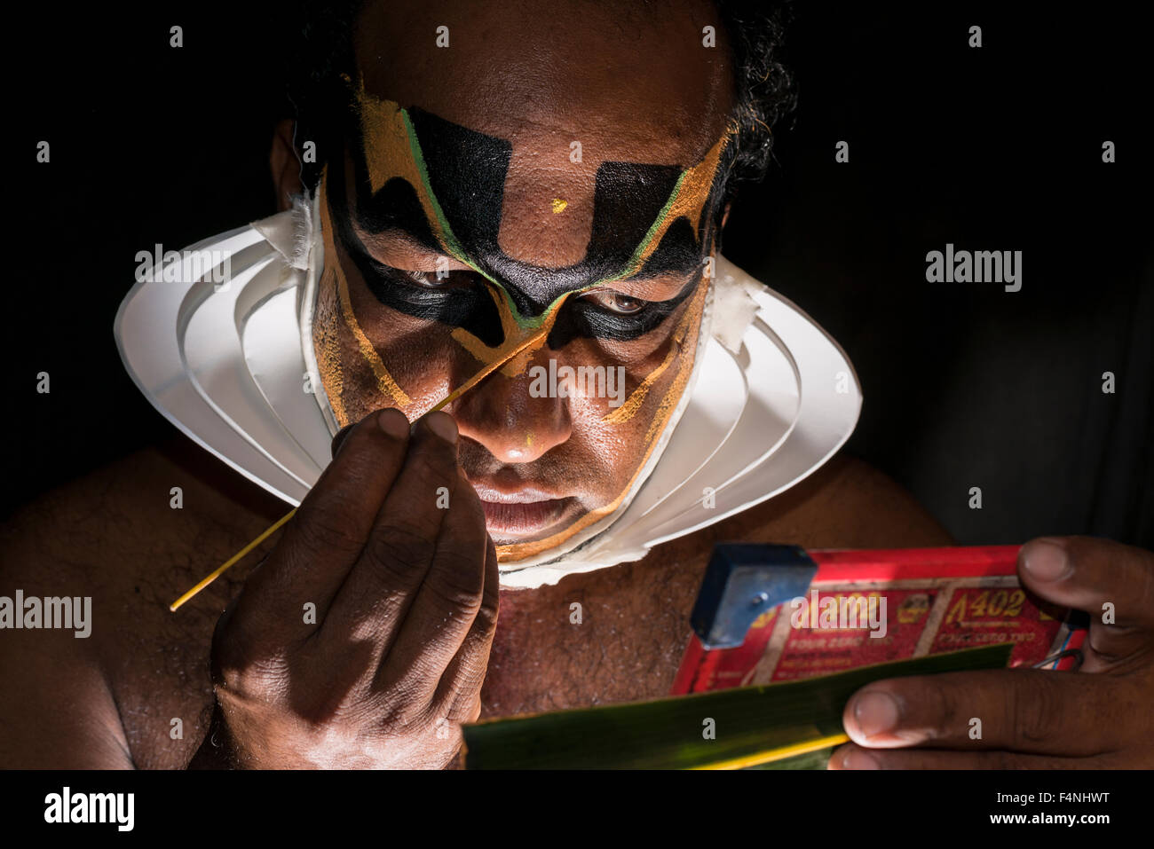 Un artista katakali è applicare il make up del carattere di Shiva per il gioco dhecheyagam Foto Stock