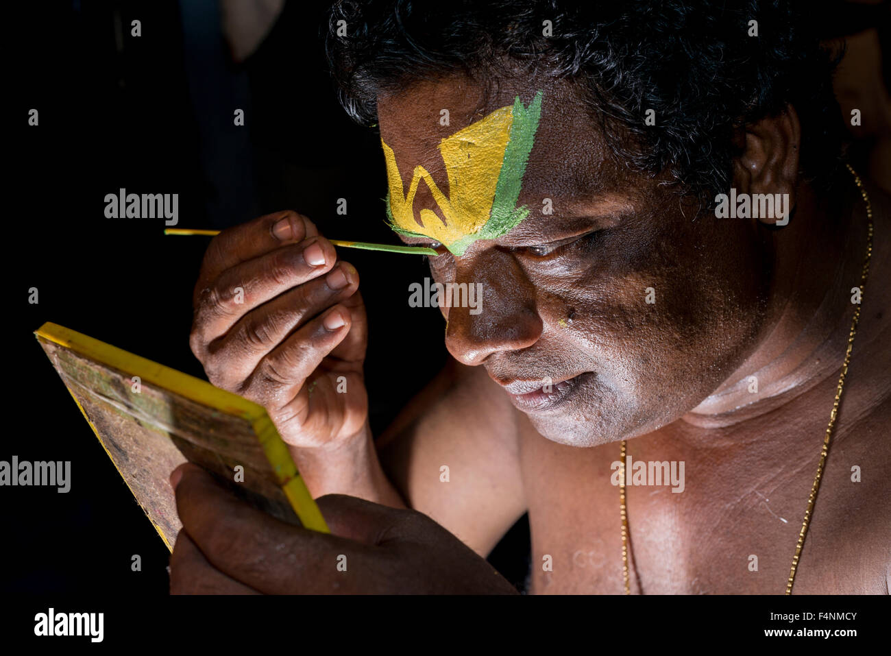 Un artista katakali è applicare il make up del carattere deshen per il gioco dhecheyagam Foto Stock