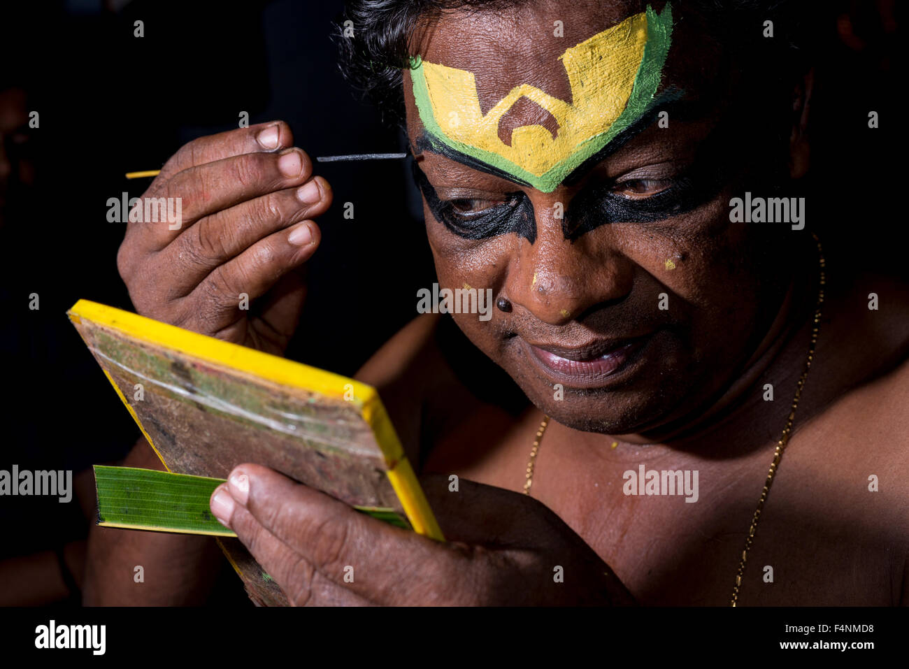 Un artista katakali è applicare il make up del carattere deshen per il gioco dhecheyagam Foto Stock