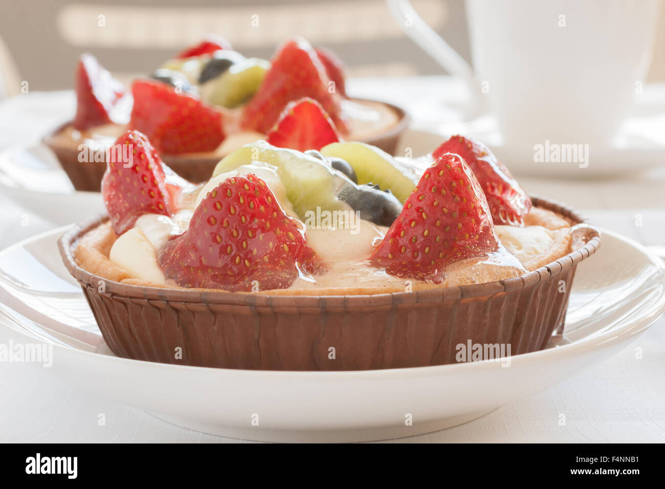 Crostate di frutta fatta riempito con crema di fragole patissiere kiwi e mirtilli Foto Stock