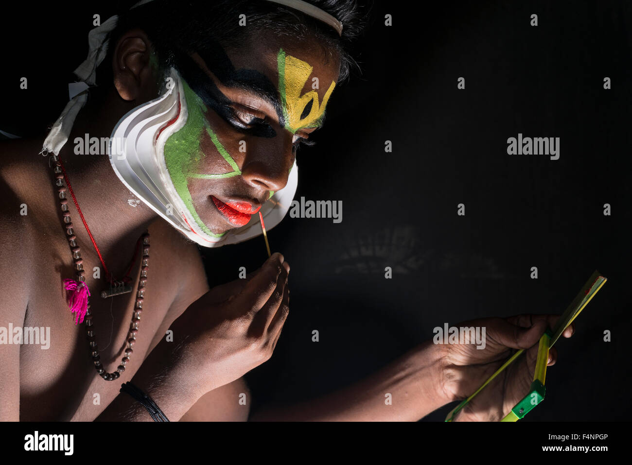Un artista katakali è applicare il make up del carattere arjun per il gioco santhana gopalam durante il tempio thriballor fest Foto Stock