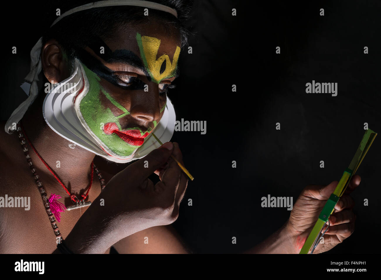 Un artista katakali è applicare il make up del carattere arjun per il gioco santhana gopalam durante il tempio thriballor fest Foto Stock