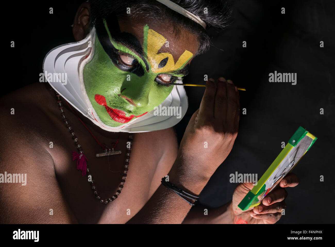 Un artista katakali è applicare il make up del carattere arjun per il gioco santhana gopalam durante il tempio thriballor fest Foto Stock