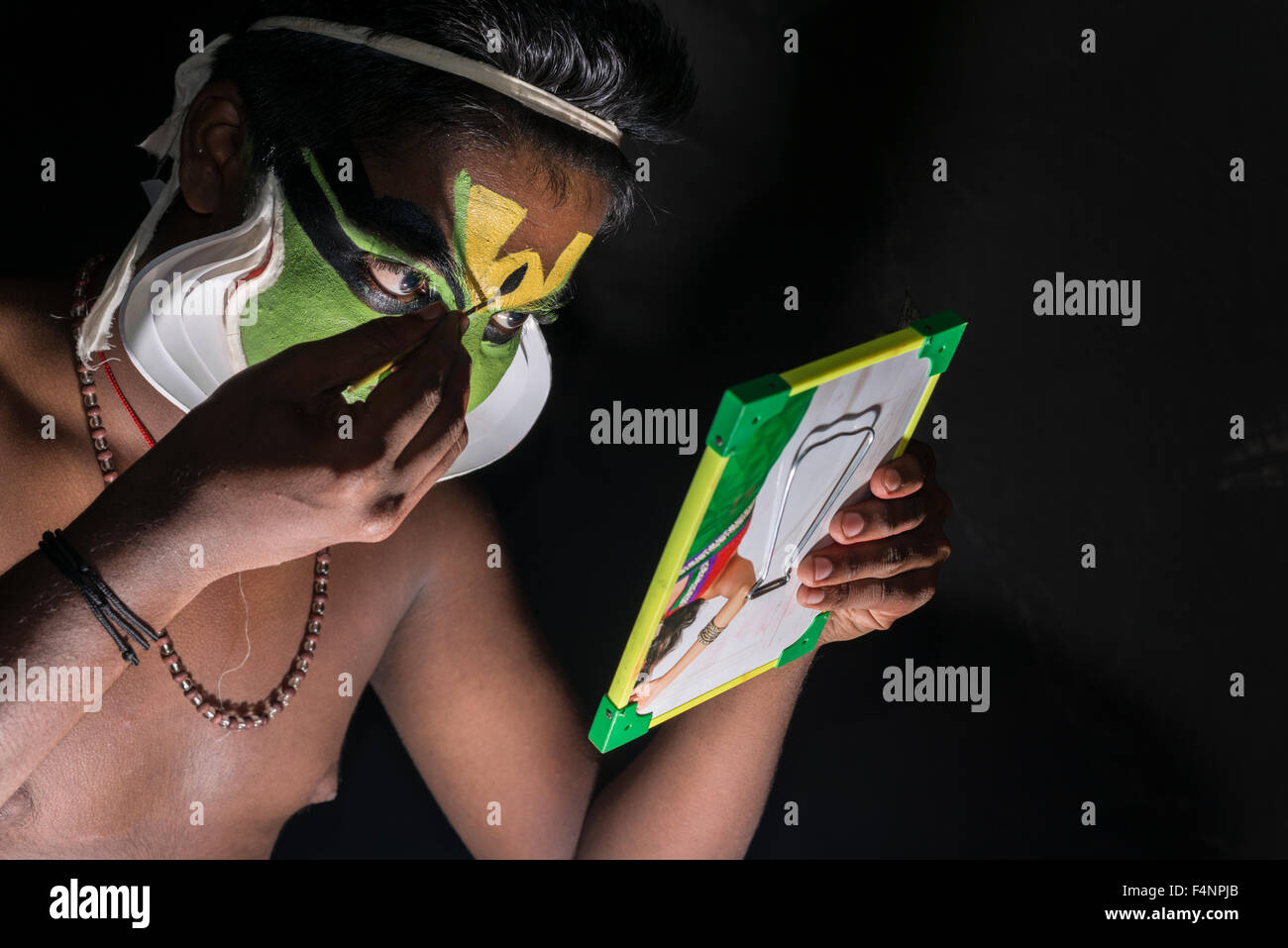 Un artista katakali è applicare il make up del carattere arjun per il gioco santhana gopalam durante il tempio thriballor fest Foto Stock