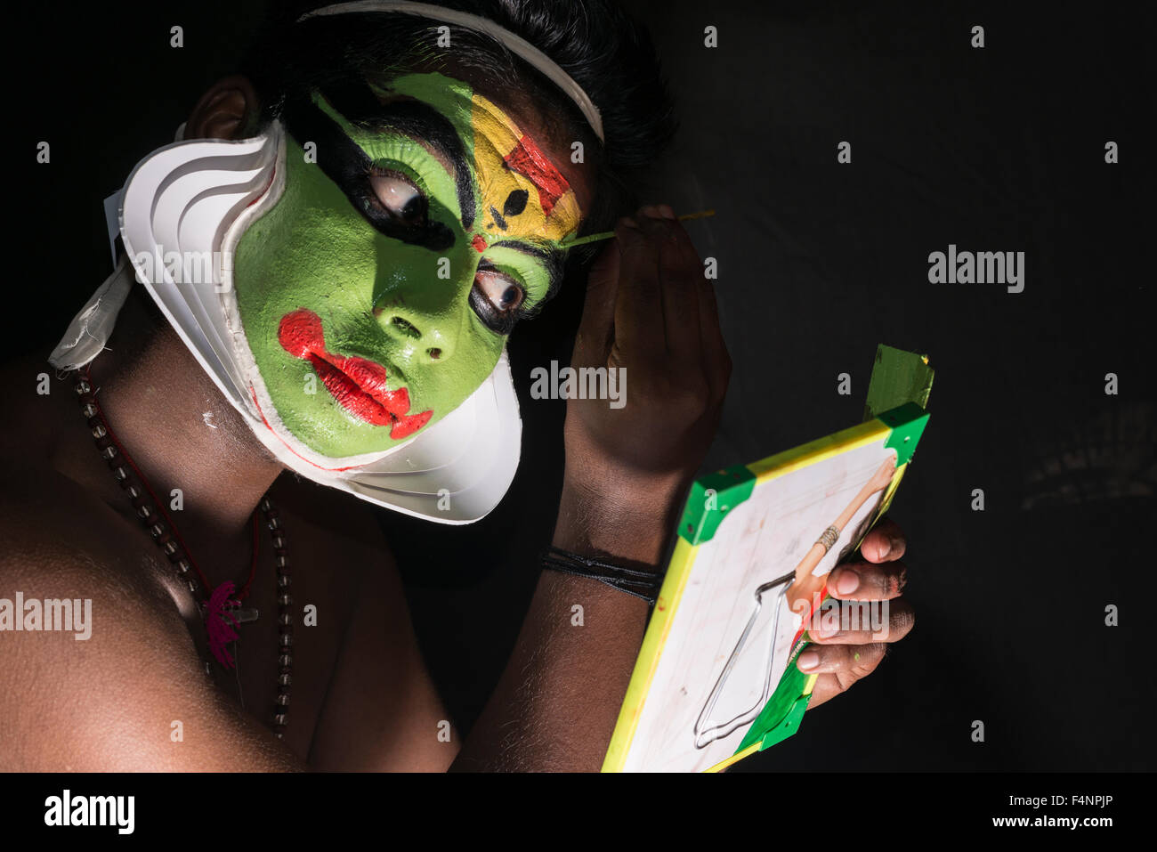 Un artista katakali è applicare il make up del carattere arjun per il gioco santhana gopalam durante il tempio thriballor fest Foto Stock