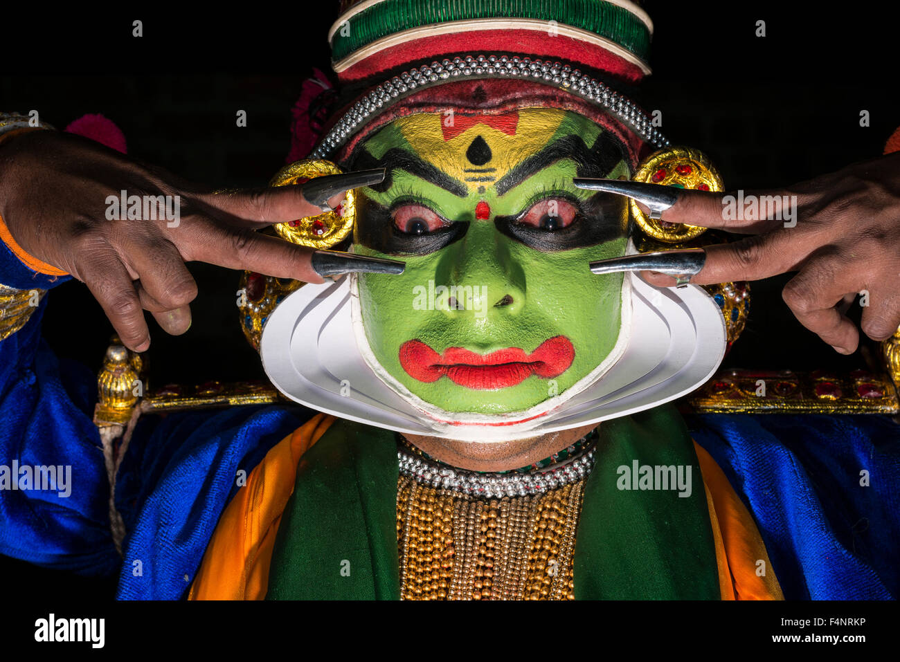 Un artista katakali è in posa con la completa make up del carattere di krishna per il gioco santhana gopalam durante il thriball Foto Stock