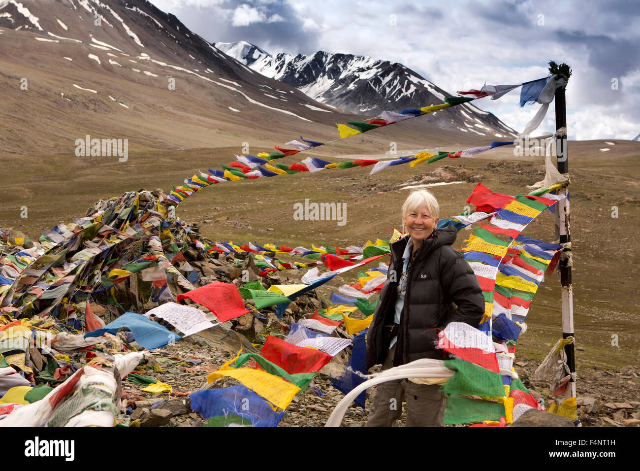 India, Himachal Pradesh, Baralacha Pass top, senior turista la preghiera buddista bandiere al vertice Foto Stock