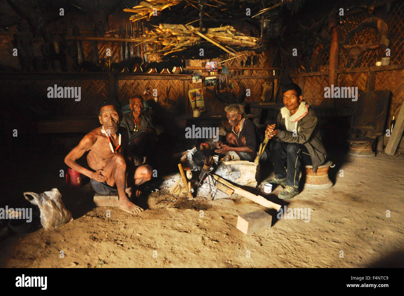 Il Nagaland, India - Marzo 2012: gli uomini seduti intorno al fuoco del Nagaland, remota regione dell India. Documentario editoriale. Foto Stock
