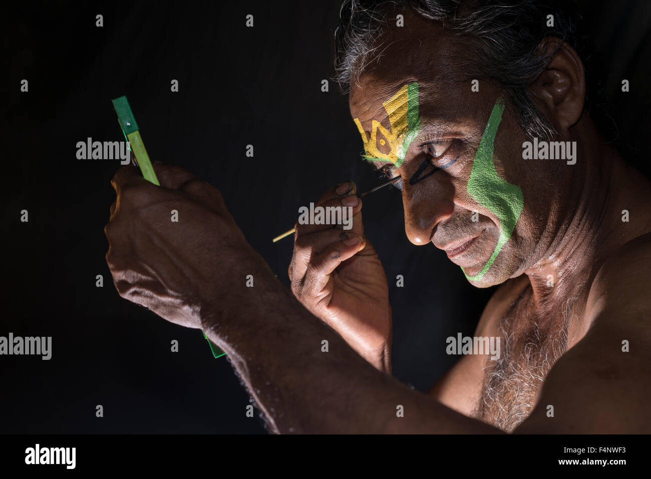 Un artista katakali è applicare il make up del carattere arjun per il gioco kiritam durante il thriballor festival tempio Foto Stock