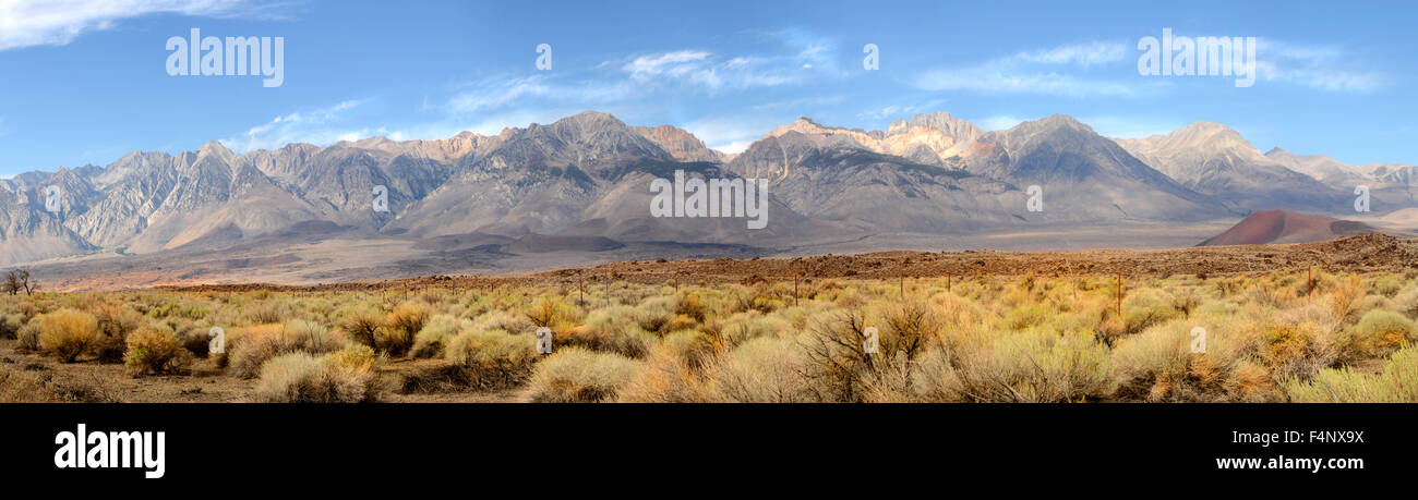 Panorama della punta meridionale delle montagne della Sierra Nevada in California centrale sotto un cielo blu chiaro con wispy nuvole bianche Foto Stock