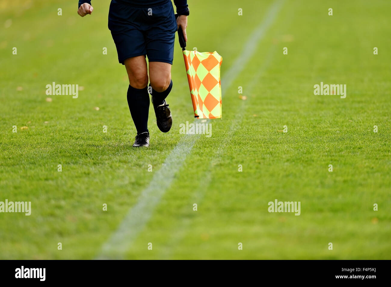 Assistente arbitro che corre lungo il diversivo durante una partita di calcio Foto Stock