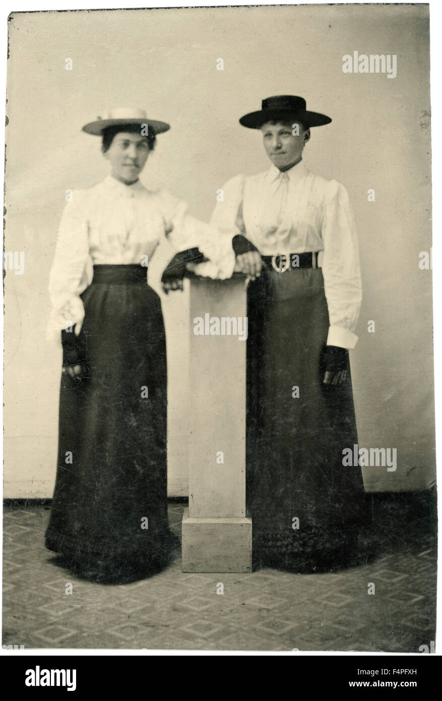 Ritratto di due donne adulte in cappelli e abiti lunghi appoggiata sul pilastro, circa 1870 Foto Stock
