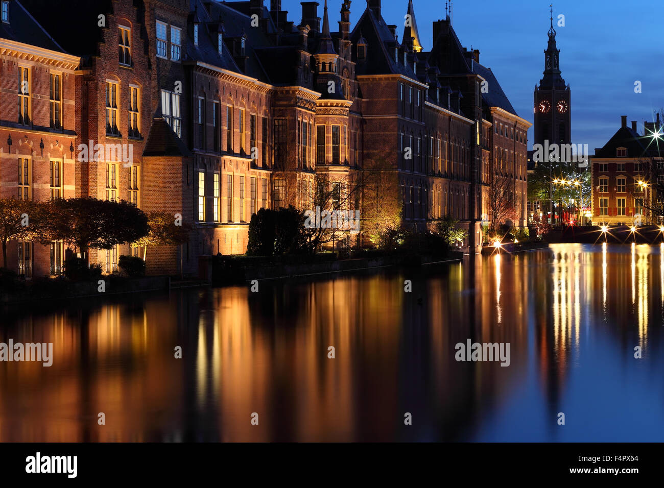 Palazzo del Senato del parlamento olandese complesso accesa al tramonto a L'Aia, Paesi Bassi. Nella parte posteriore, Grote Kerk tower Foto Stock