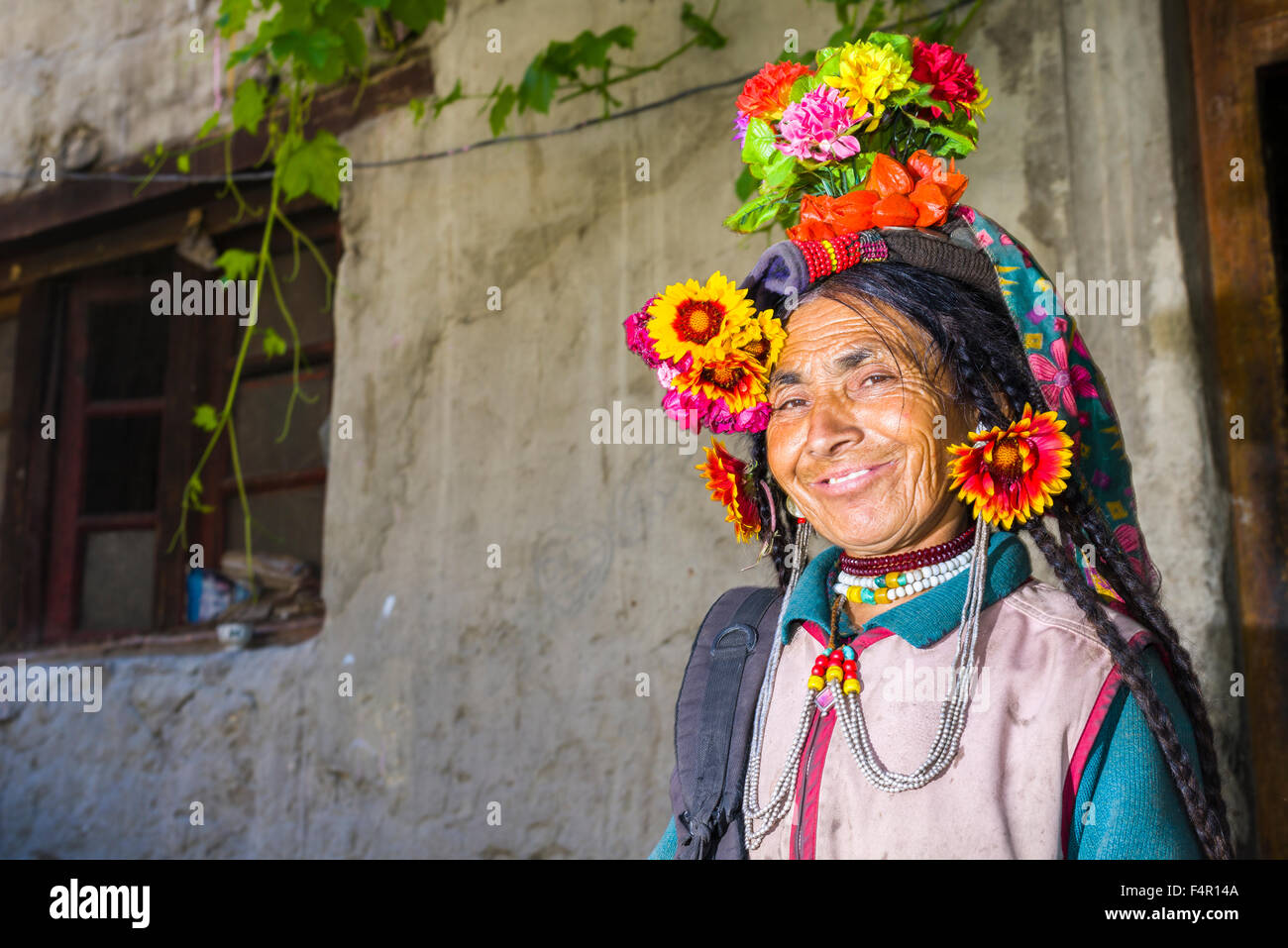 Una donna della tribù brokpa, una gara arien, nel suo abito tradizionale con una disposizione del fiore portato sulla testa Foto Stock