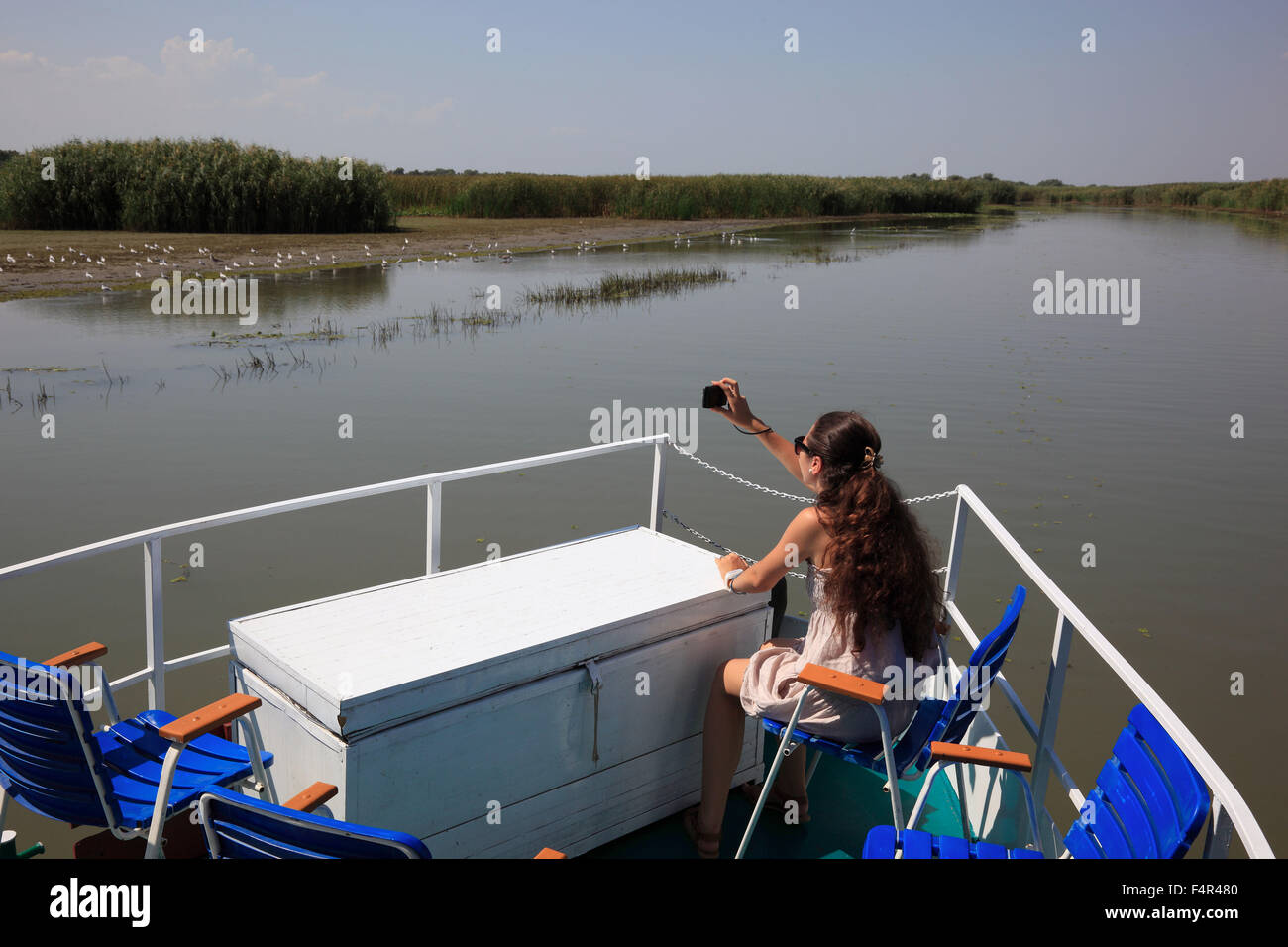 Tourist fotografare su una barca per gite nel Delta del Danubio Riserva della Biosfera, vicino a Tulcea, Romania Foto Stock