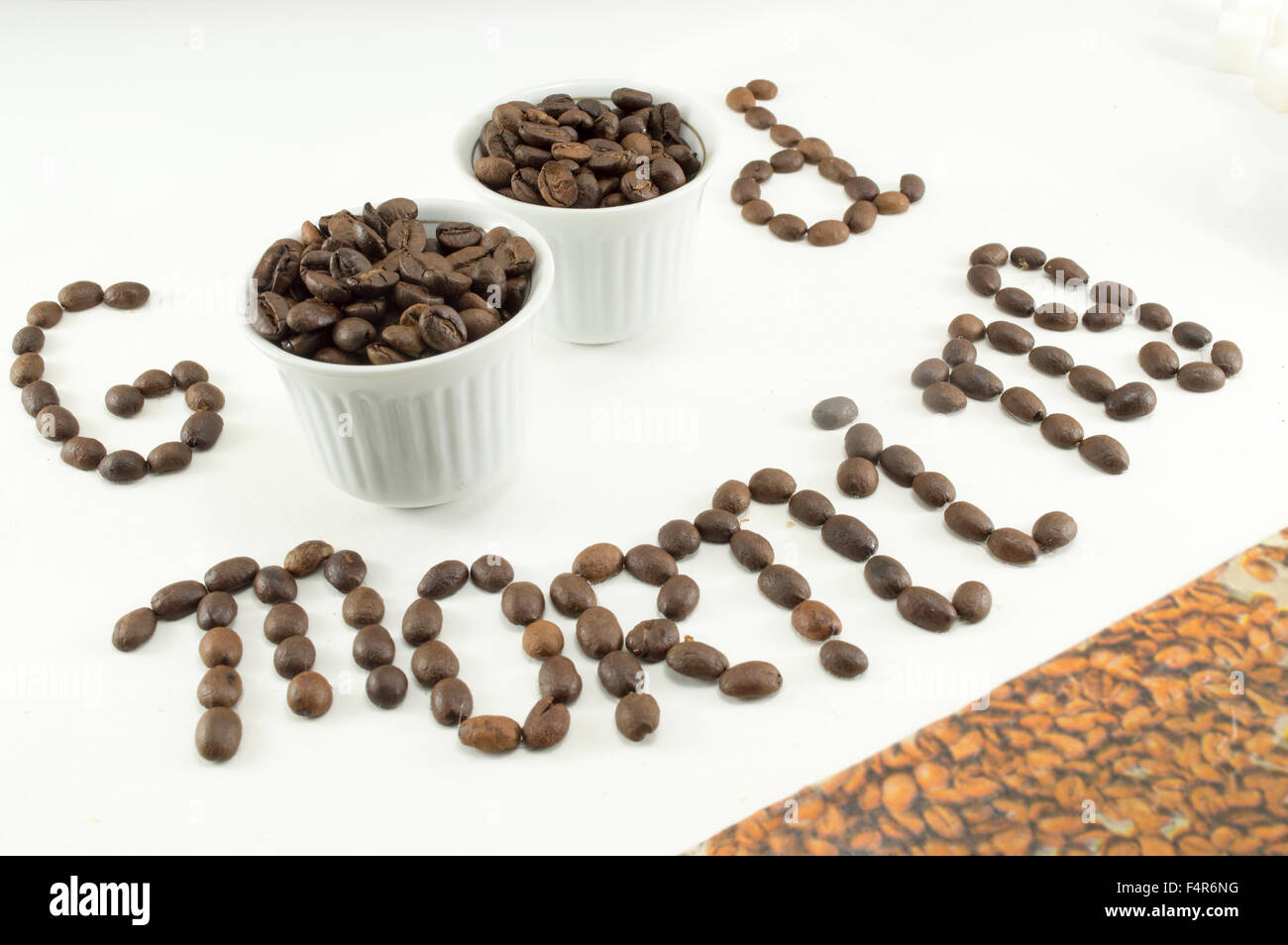 Due tazze di caffè in grani formando un 'Good morning' nota Foto Stock