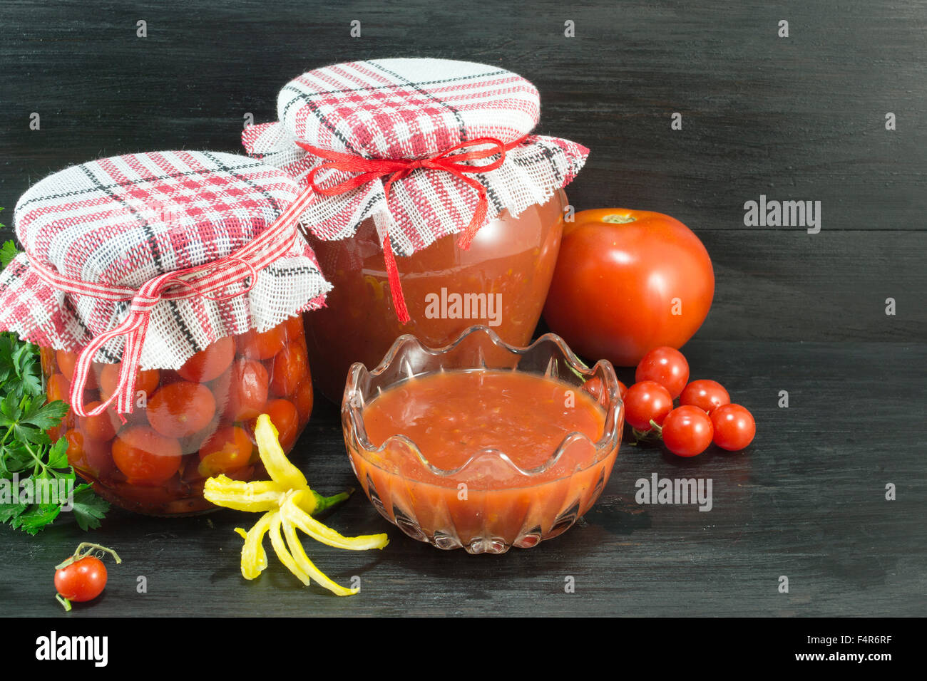 Salsa di pomodoro in varie forme su sfondo scuro Foto Stock
