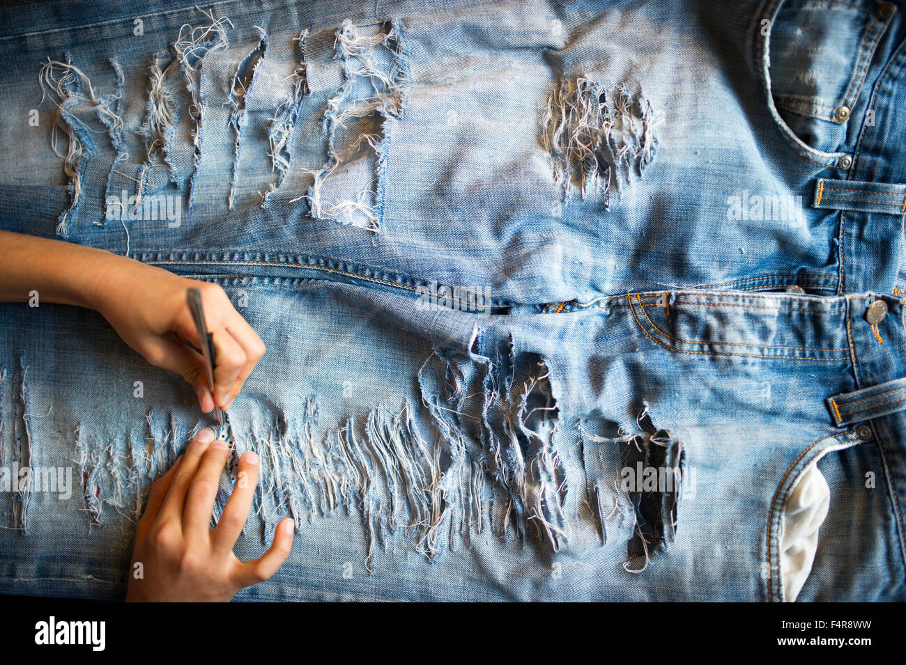 Ragazza giovane è il suo taglio jeans (MR) Foto Stock