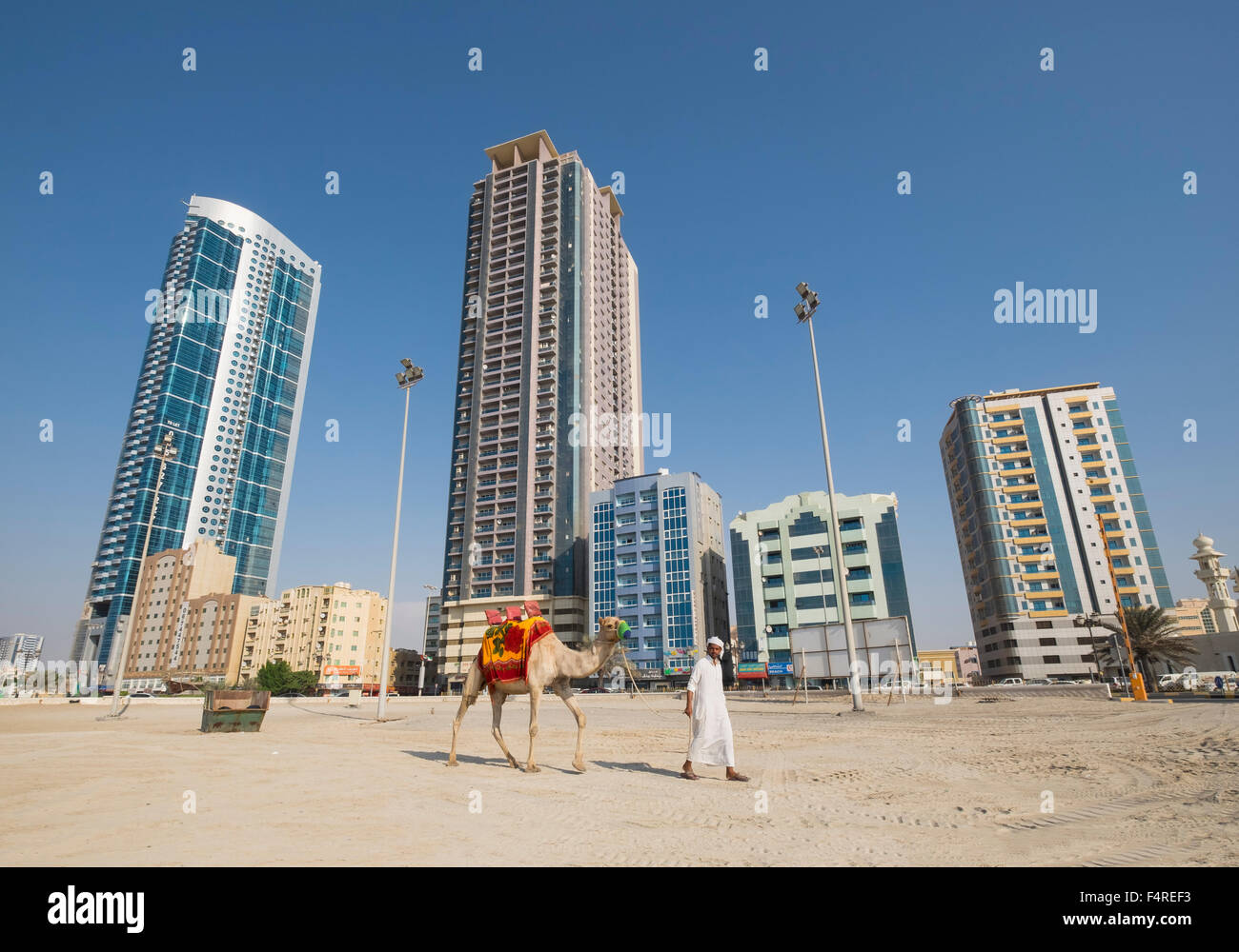 Uomo con cammello camminando sulla spiaggia sul lungomare di Ajman emirato negli Emirati Arabi Uniti Foto Stock Uomo con cammello camminando sulla spiaggia sul lungomare di Ajman emirato negli Emirati Arabi Uniti Foto Stock