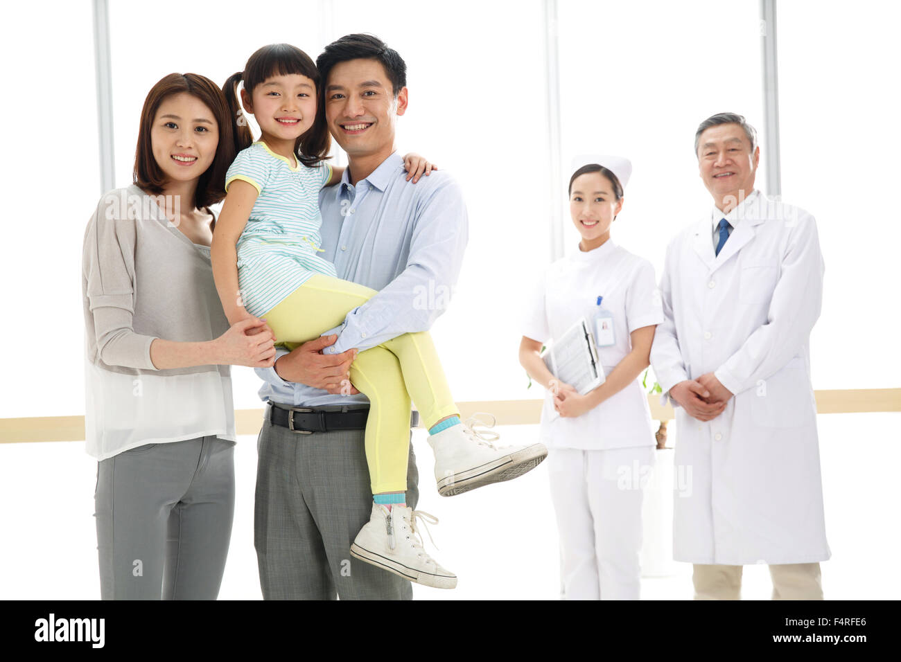 Una famiglia di tre persone e lavoratori medici Foto Stock