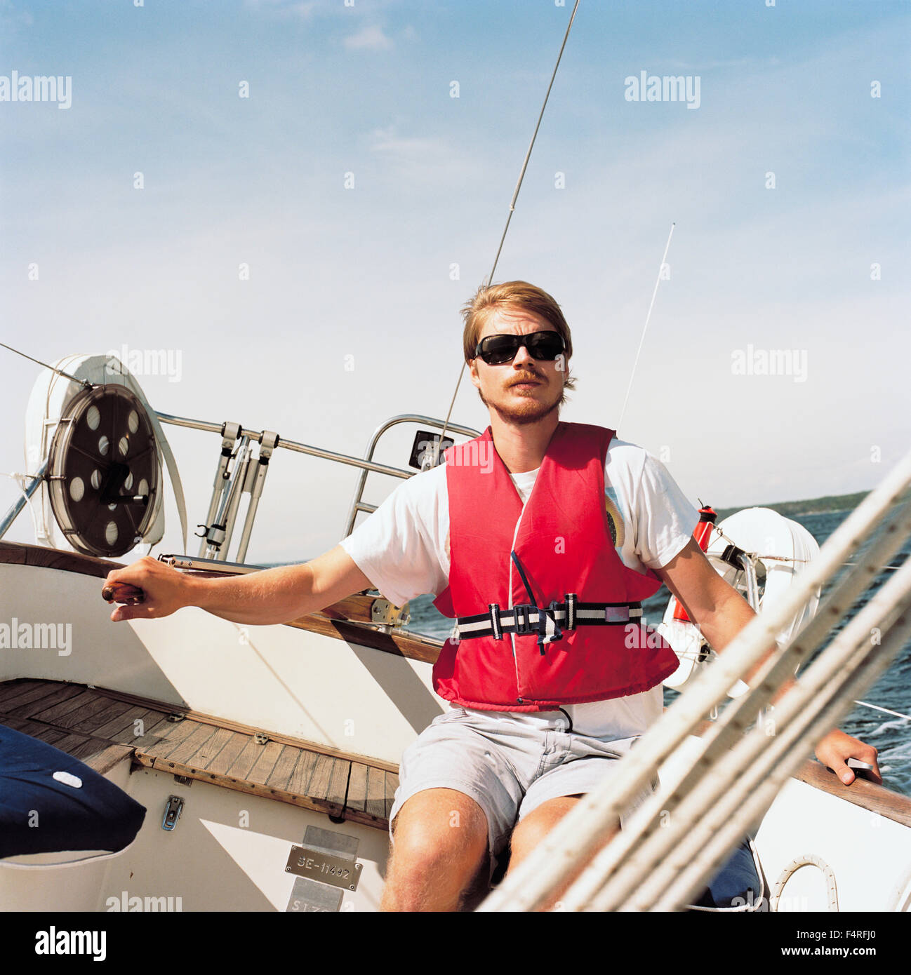 La Svezia, Uppland, arcipelago di Stoccolma, metà uomo adulto sulla poppa della barca a vela Foto Stock