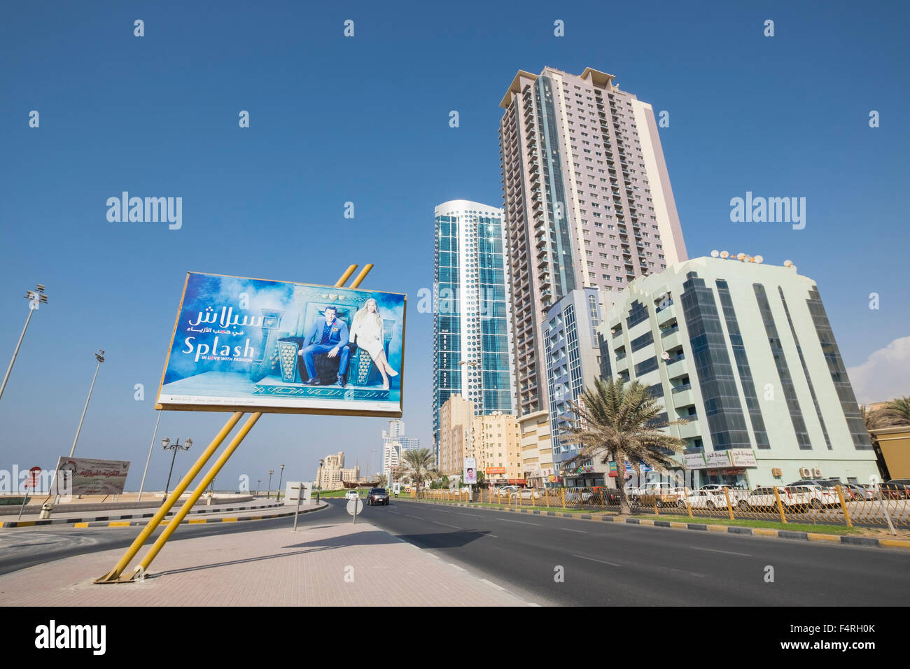 Vista della strada e alta e moderni edifici sulla Corniche street in Ajman emirato negli Emirati Arabi Uniti Foto Stock
