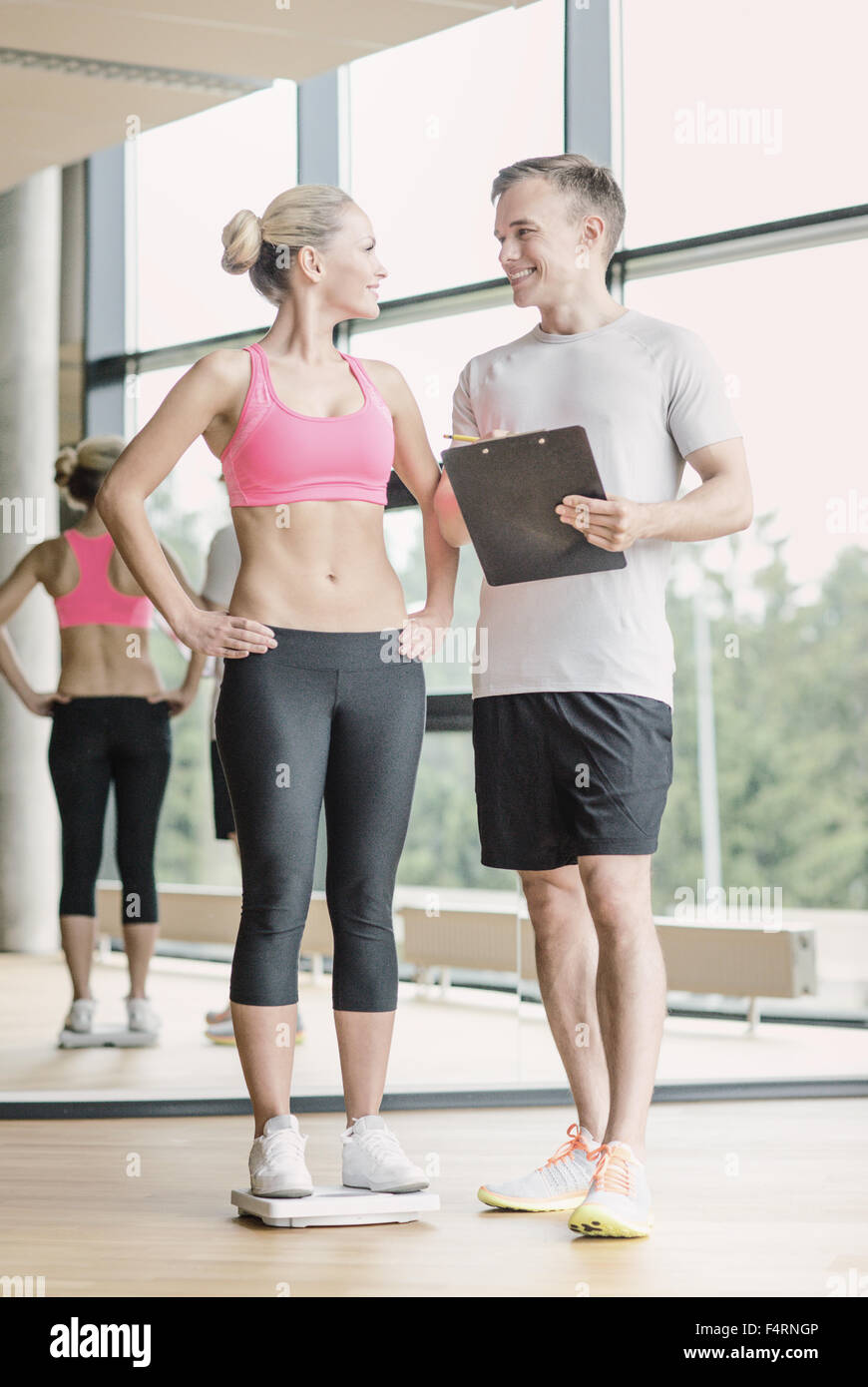 Uomo sorridente e donna con scale in palestra Foto Stock