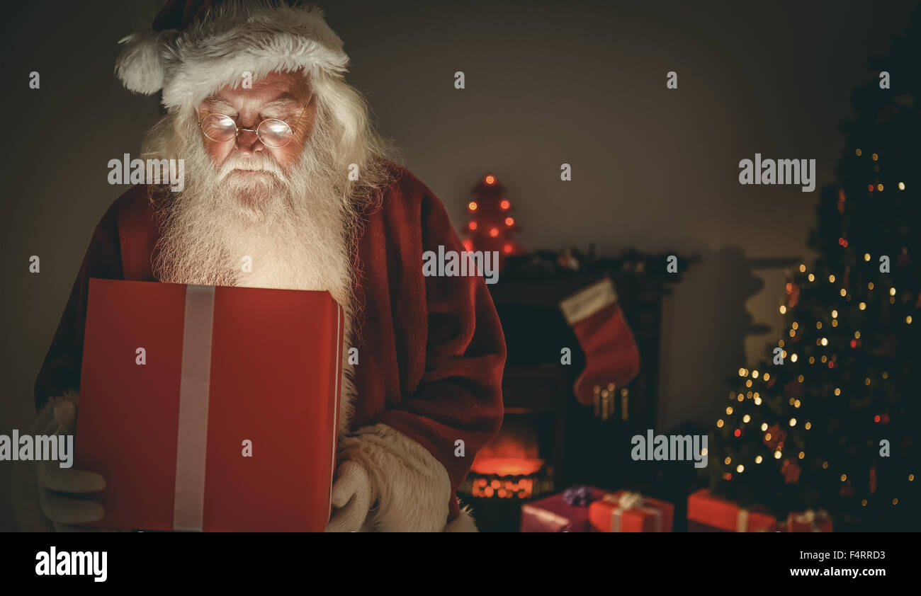 Santa Claus offrendo un dono incandescente Foto Stock