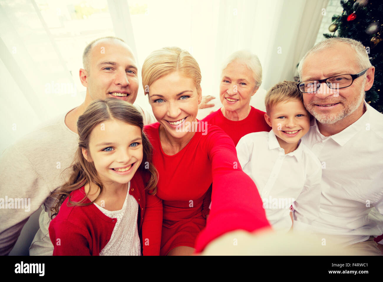 Famiglia sorridente rendendo selfie a casa Foto Stock