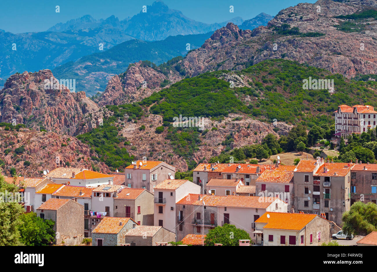 Villaggio Corso cityscape, vecchie case di pietra con tetti in tegole rosse sulle montagne sullo sfondo. Piana, Sud Corsica, Francia Foto Stock