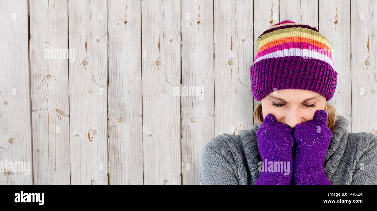 Immagine composita di congelare la donna con i guanti e un cappello Foto Stock