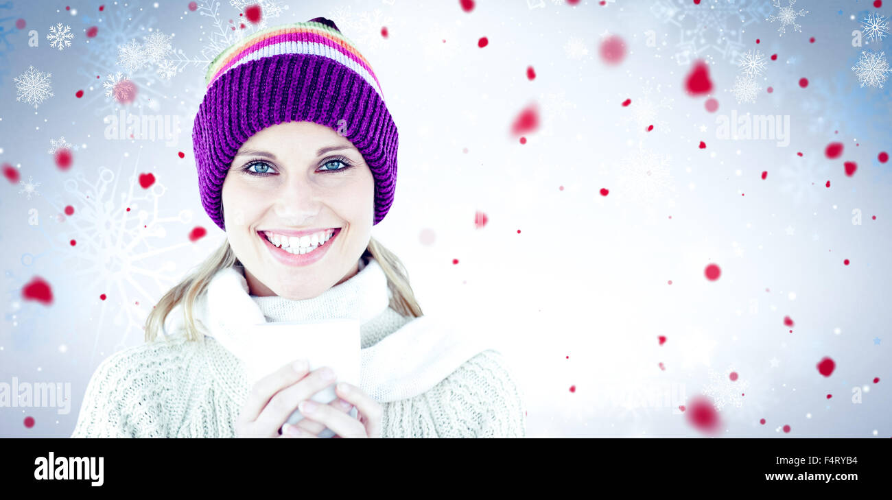 Immagine composita di incandescente donna che indossa un maglione bianco e un colorato hat contro backgrou bianco Foto Stock