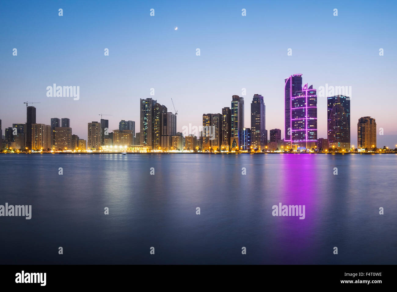 Sera vista sullo skyline di alto e moderno appartamento edifici sulla Corniche in Sharjah Emirati Arabi Uniti Foto Stock