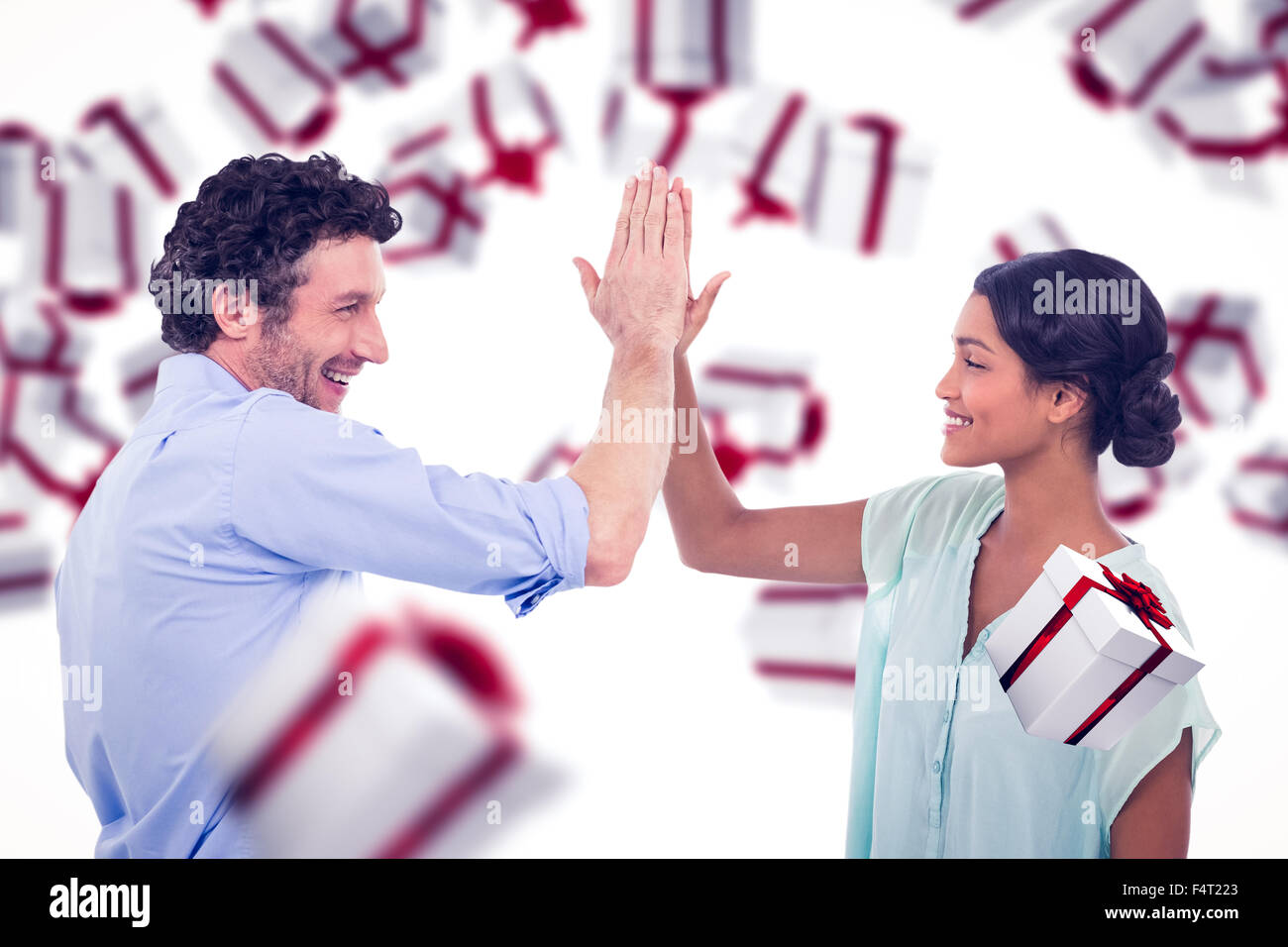 Immagine composita della gente di affari ad alta fiving su sfondo bianco Foto Stock