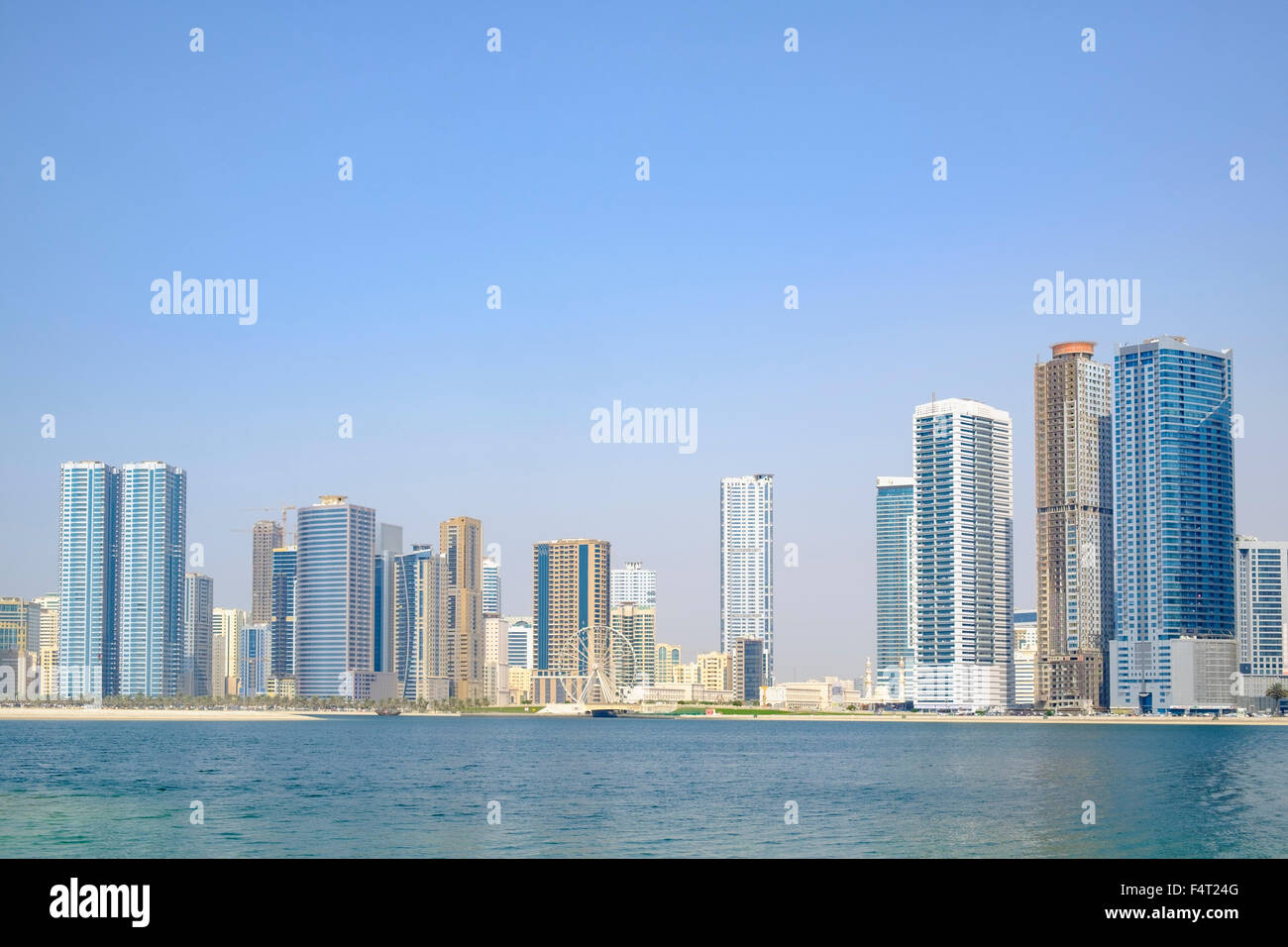 Il giorno dello skyline di spiaggia e alto e moderno appartamento edifici lungo la corniche in Sharjah Emirati Arabi Uniti Foto Stock
