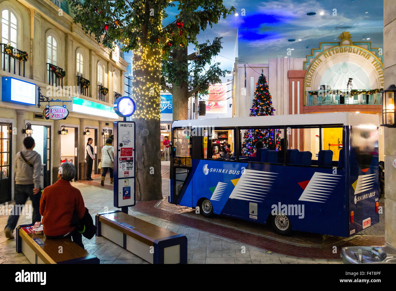 Giappone, Nishinomiya, KidZania, bambini role-play activity center. Interno, area di strada con bus Shinki guida tra la gente e costruire. Notte. Foto Stock