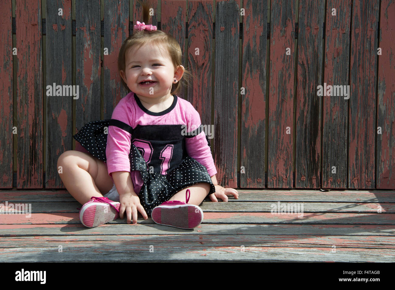 Laughing baby ubicazione su una oscillazione di legno Foto Stock