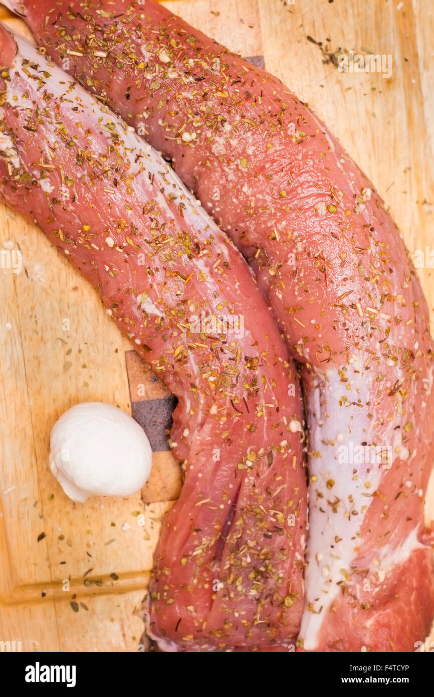 Materie di filetti di maiale nelle erbe preparato per la cottura sulla scheda di cucina. Foto Stock