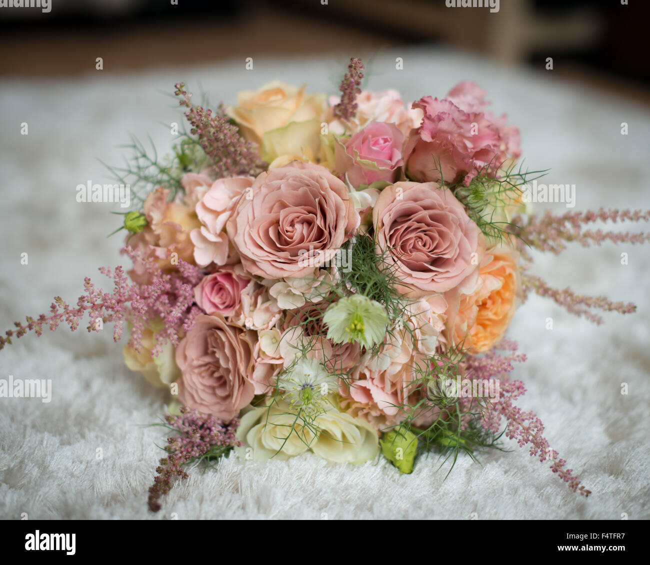 Bouquet nozze giacente sul letto di rose di pesche gialle con rose rosa e verde fogliame spose di fiori di nozze Foto Stock