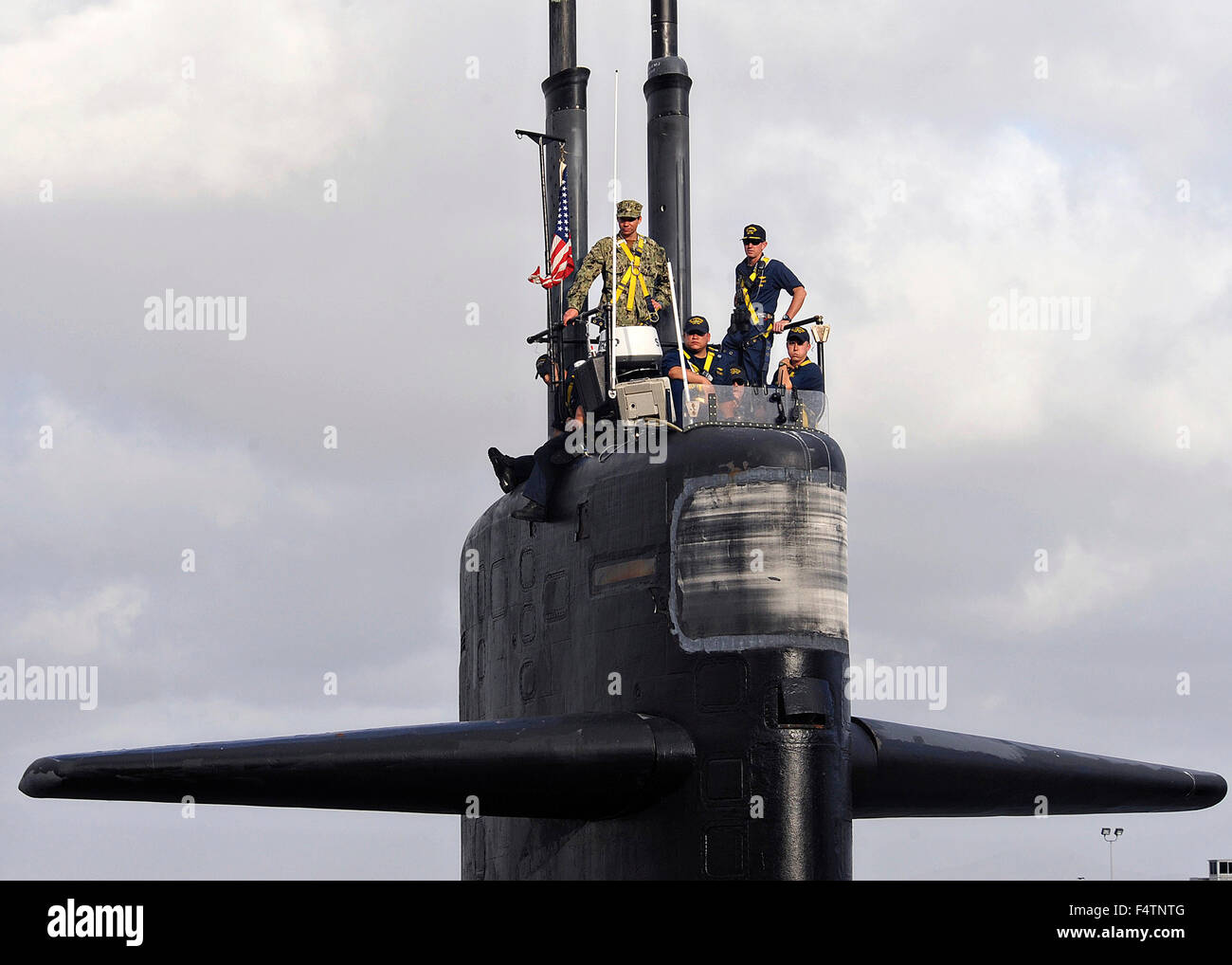 US Navy Cmdr. Donald Tenney (a destra), comandante della Los Angeles-classe fast-attacco sommergibile USS Albuquerque, sorge sul ponte come la nave parte per l'ultimo viaggio alla Base Navale di Point Loma Ottobre 21, 2015 a San Diego, California. Il sub dovrà intraprendere un viaggio di Puget Sound Naval Shipyard per lo smantellamento dopo 32 anni di servizio. Foto Stock