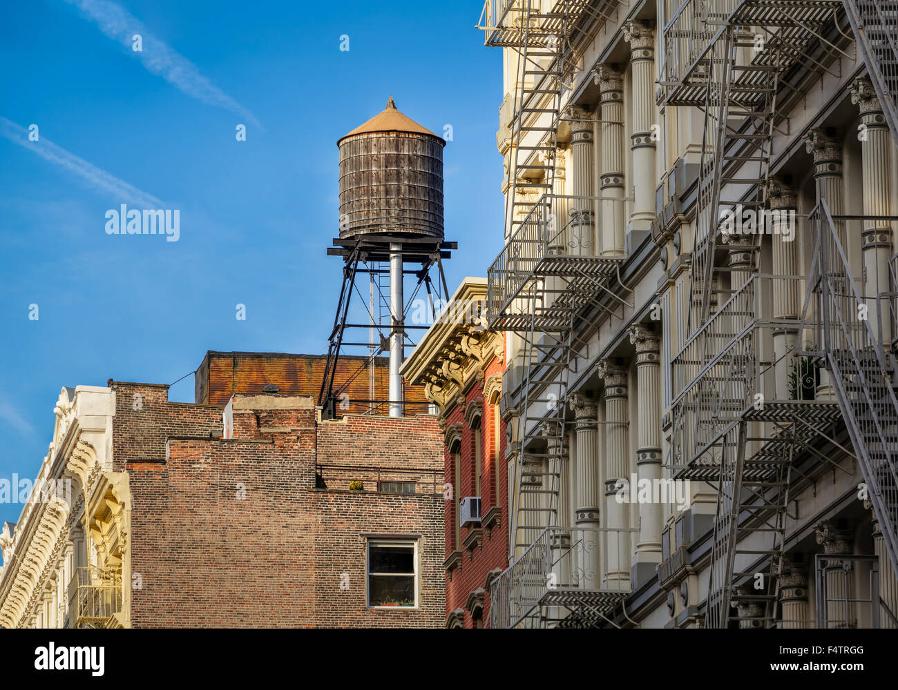 Legno serbatoio acqua e ghisa facciata degli edifici con il fuoco sfugge, Soho Downtown Manhattan, New York City Foto Stock
