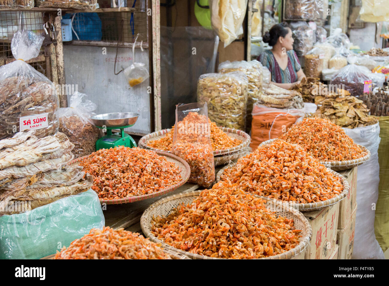 Signora vietnamita vendita di pesci secchi gamberi al suo interno in stallo Hanoi quartiere vecchio mercato,Vietnam Foto Stock