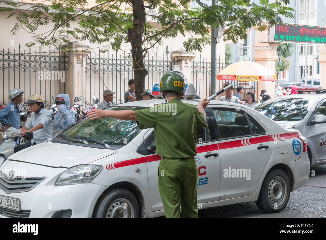 Vietnames epoliceman office rin uniforme verde dirige il traffico di Hanoi centro,Vietnam Foto Stock