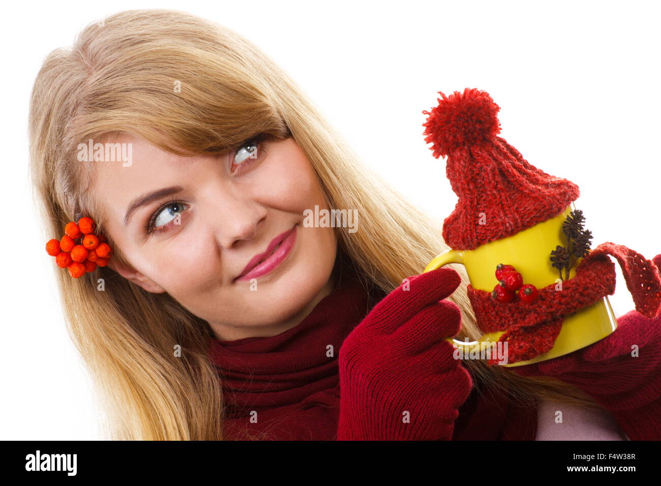 Donna felice in guanti di lana con rowan nella sua azienda per capelli coppa gialla con sciarpa di lana e cappuccio, autunno decorazione, Foto Stock