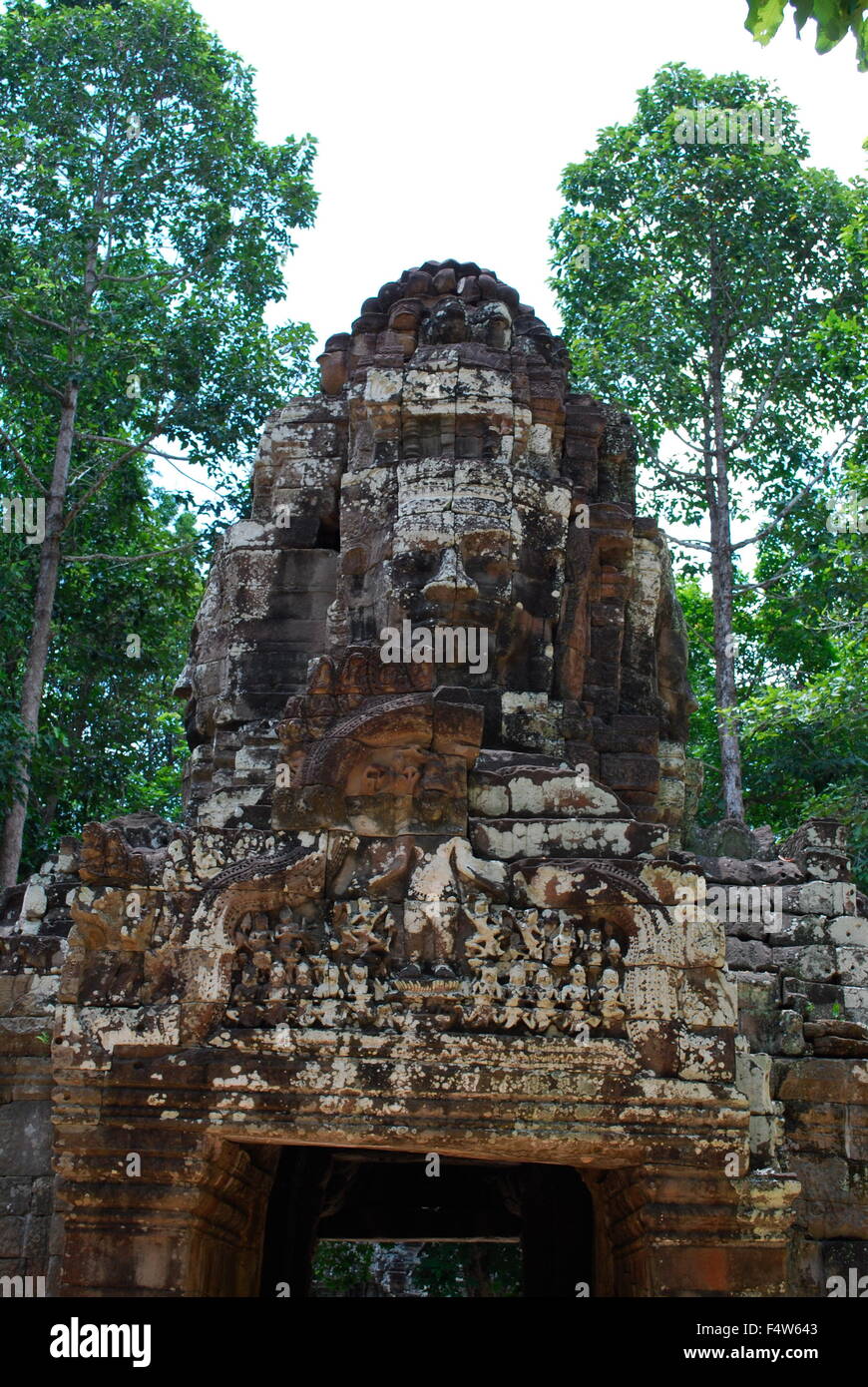 Gateway per antica Ta Som tempio di Angkor, Siem Reap, Cambogia. Gopura con un gigante di pietra di fronte e boschi in background. Foto Stock