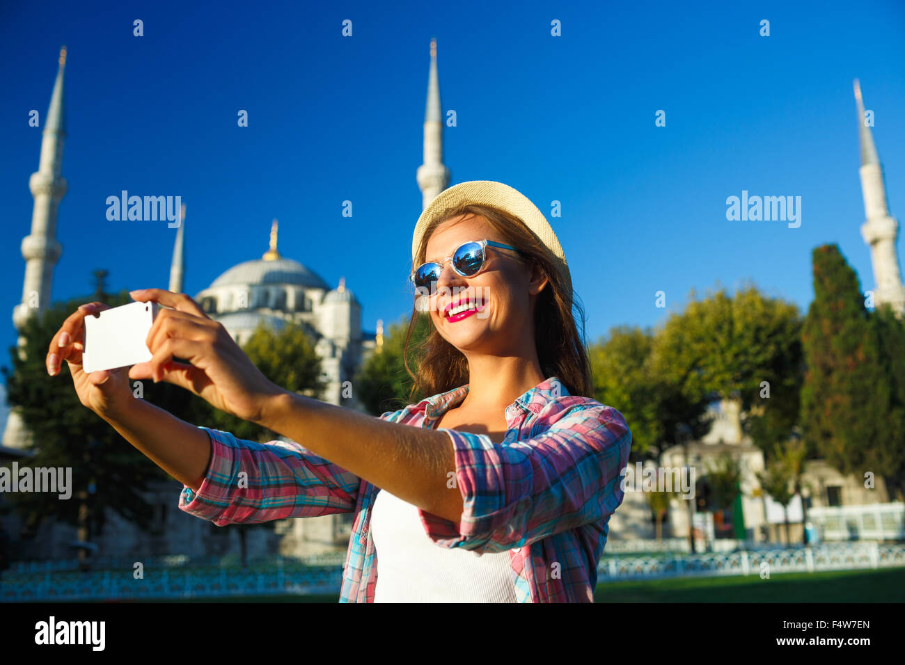 Ragazza in hat rendendo selfie dallo smartphone sullo sfondo della Moschea Blu, Istanbul. Turchia Foto Stock